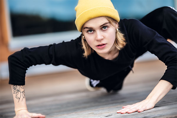 Tanssija katsoo kameraan keltainen pipo päässään.