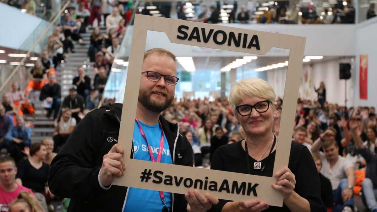 Iso joukko ihmisiä kampuksella.
