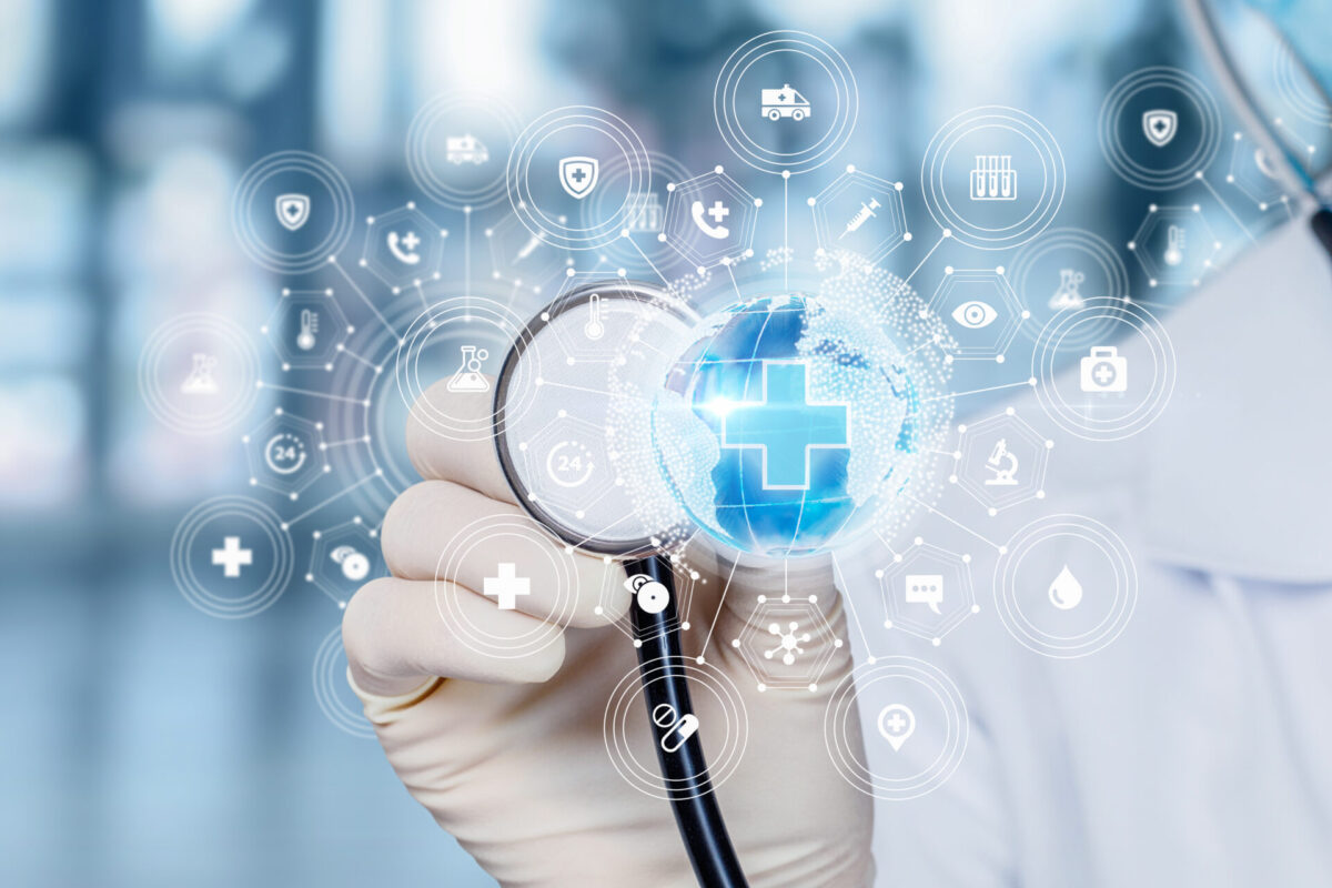 Picture of the hand of a doctor holding a stethoscope in the back of a small blue Earth globe
