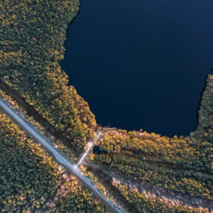 Kuvituskuvassa kuvattu järvimaisema ylhäältä käsin, kuvassa näkyy järven lisäksi metsää ja maantietä.