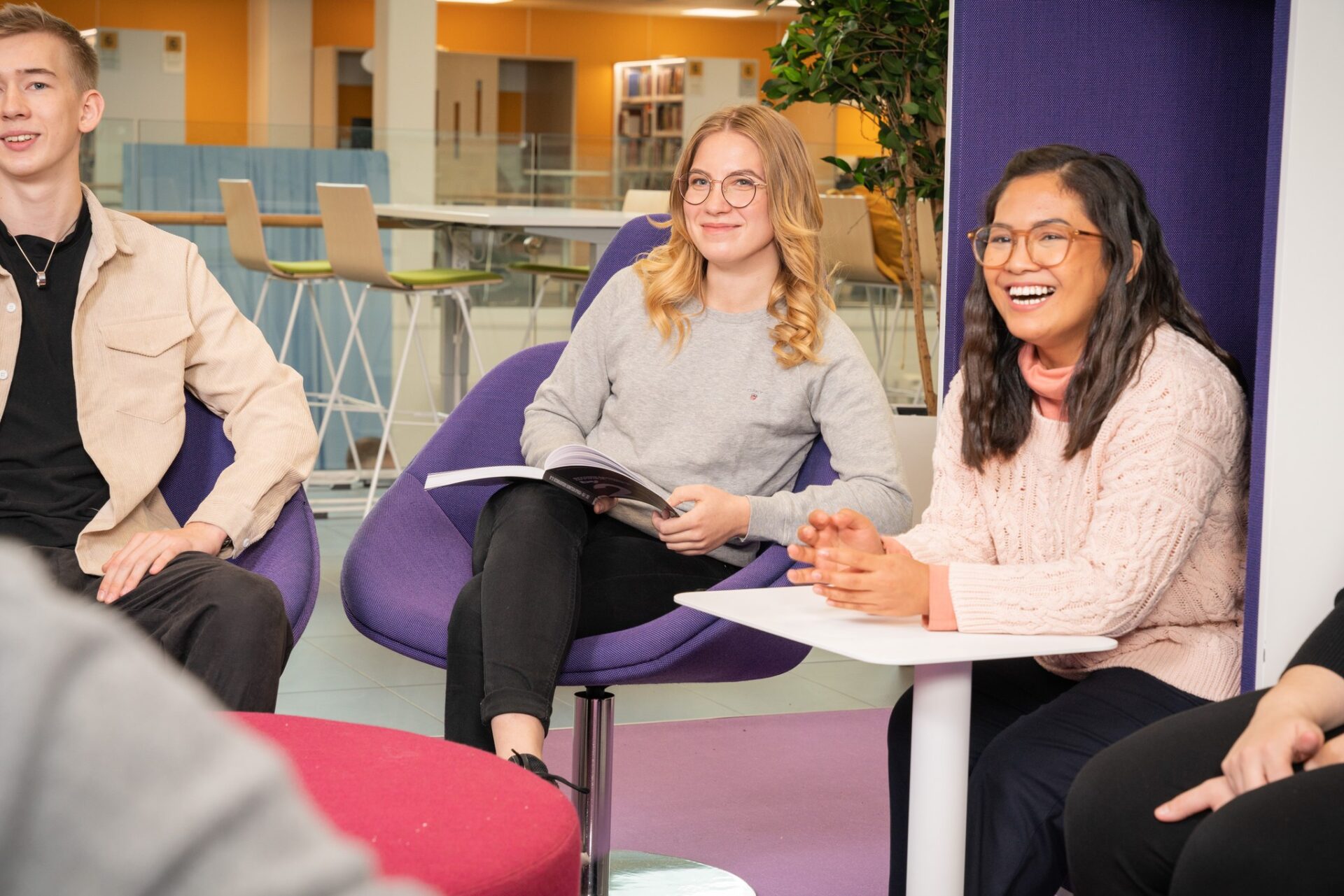 Three students sitting in the couches of Savonia's Library.