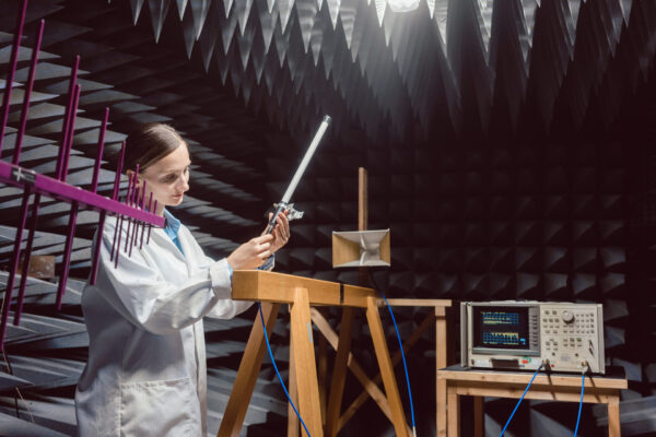 Engineer in electronics lab performing rf compliance test.