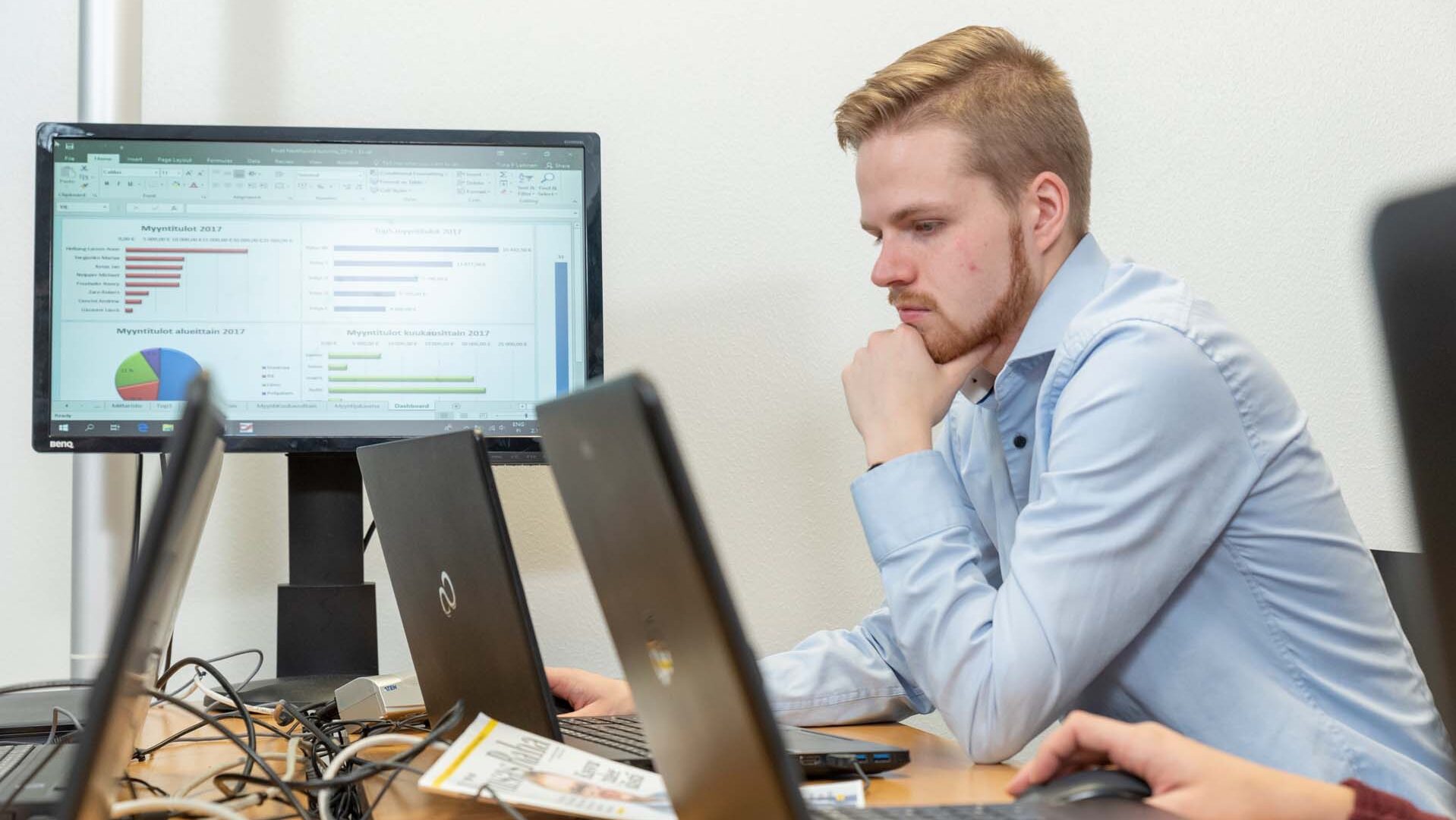 Man sitting in front of a laptop thinking and looking at its screen.