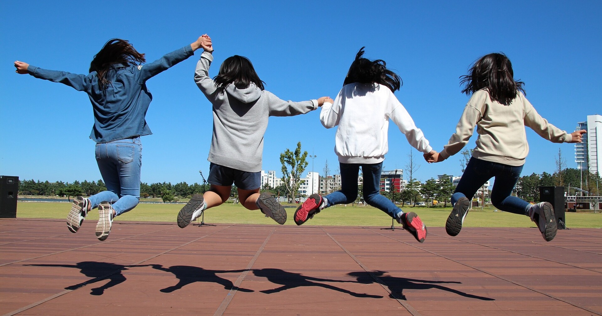 Nuoria hyppäämässä ilmaan käsikkäin