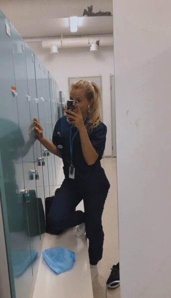 tyttö sairaanhoitajan vaatteissa ottaa selfietä peilin kautta