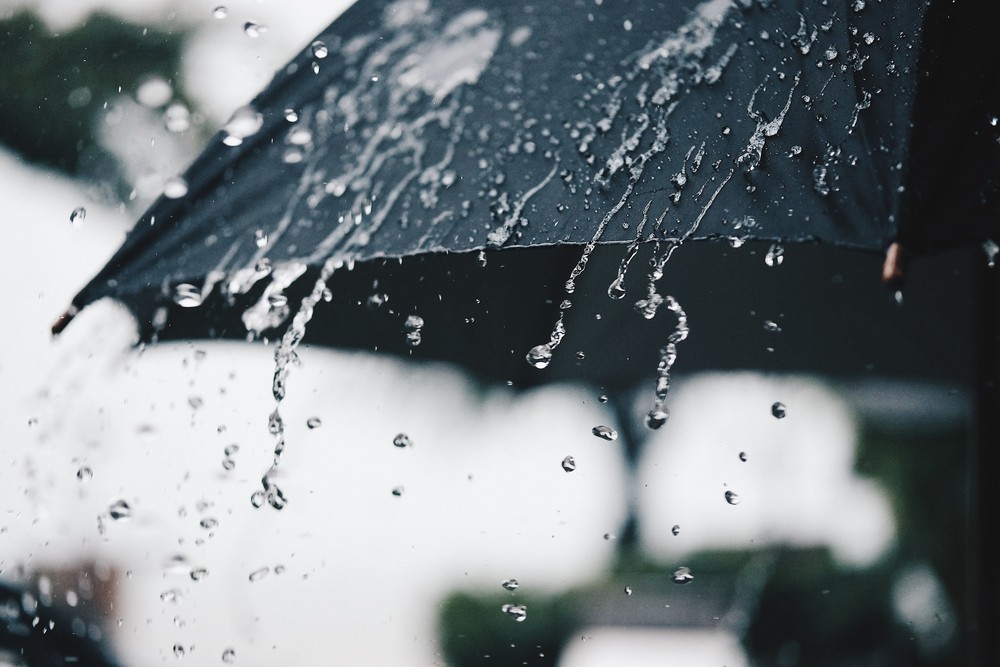 Rain falling on black umbrella.