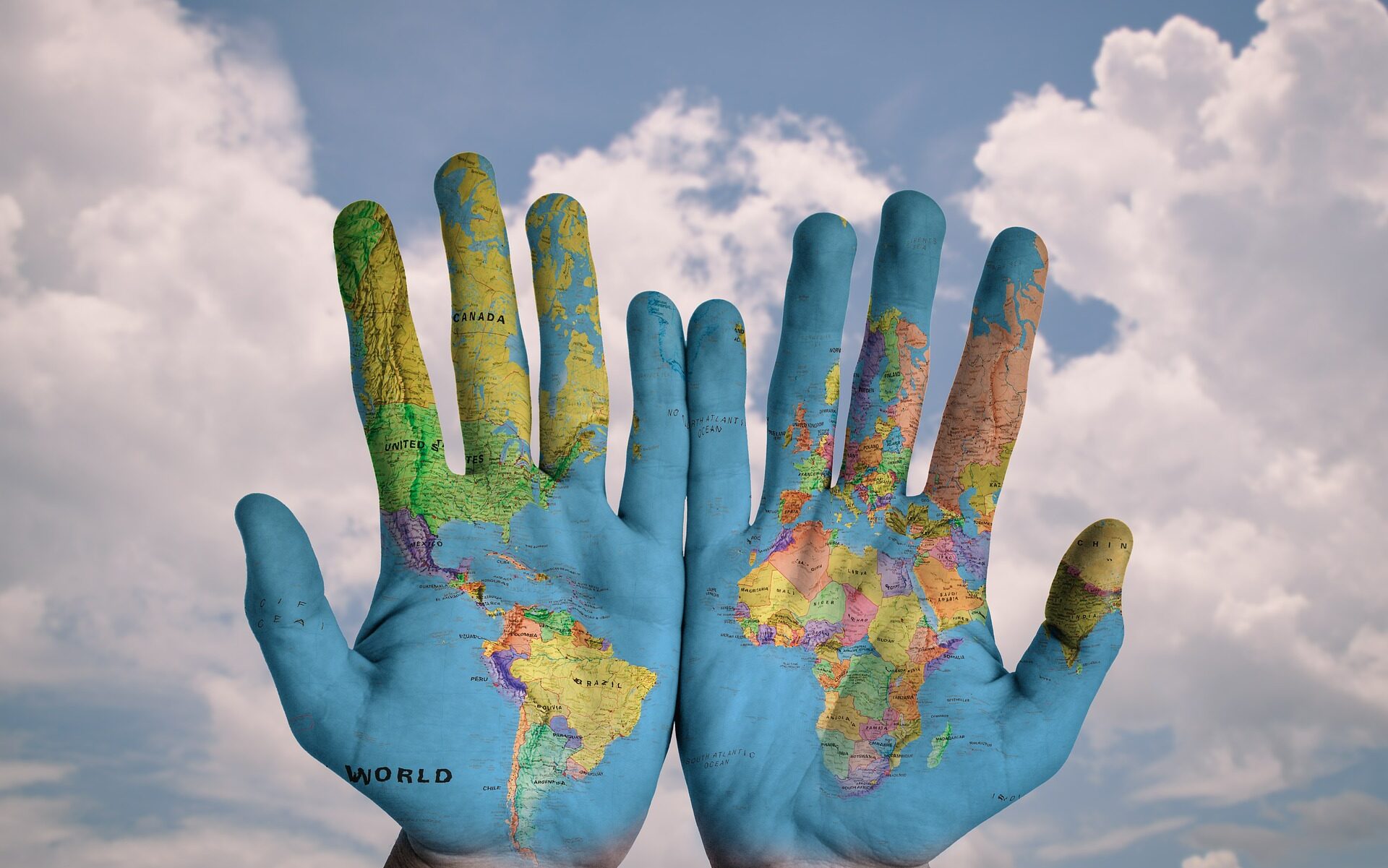 kädet, joihin on piirretty maapallon kartta