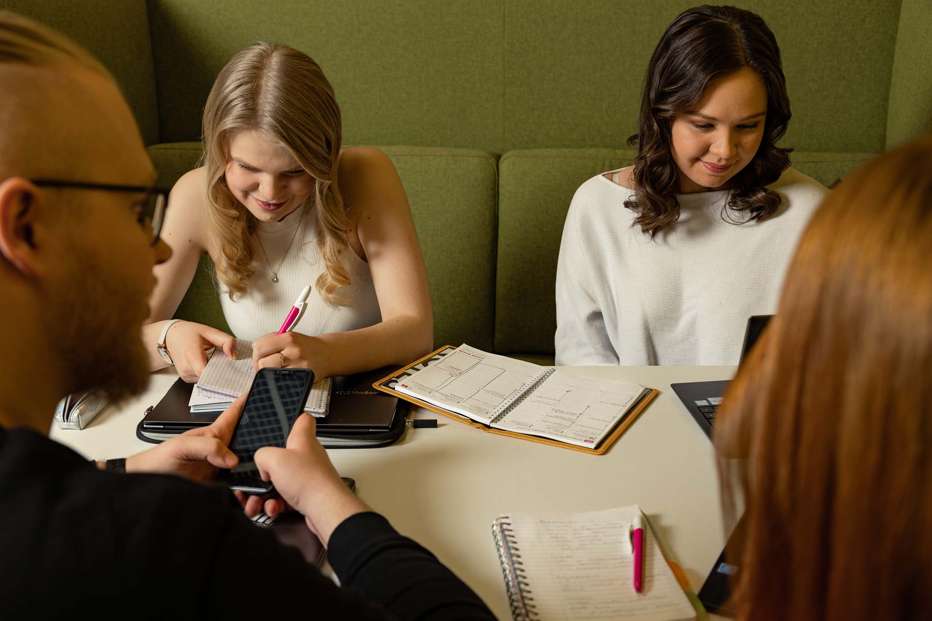 Ryhmä opiskelijoita kirjaston ryhmätyöskentelytilassa.