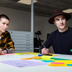 Kaksi opiskelijaa kirjoittaa post-it-lapuille.