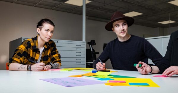 Kaksi opiskelijaa kirjoittaa post-it-lapuille.