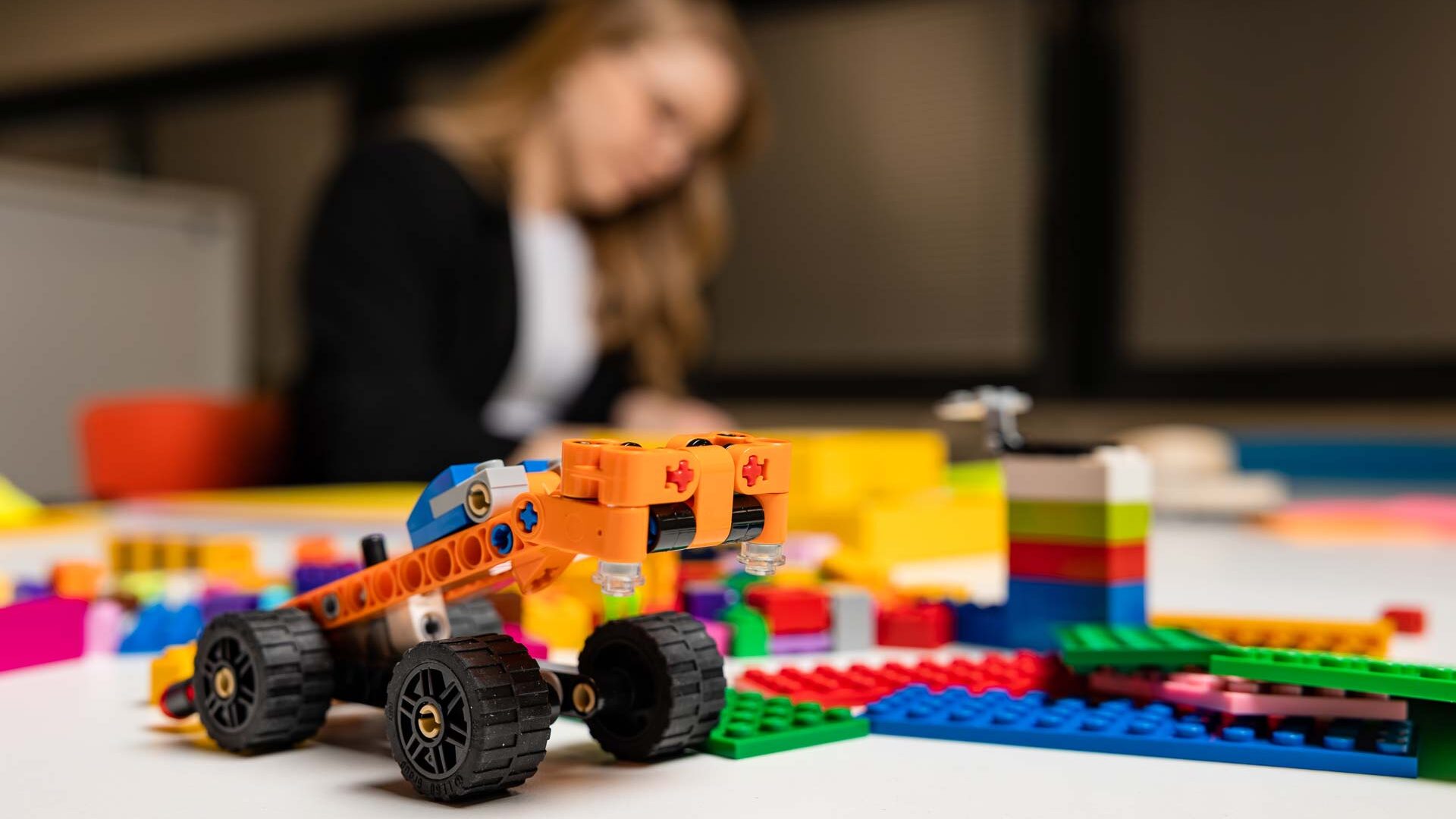 Legoauto ja taustalla opiskelija.