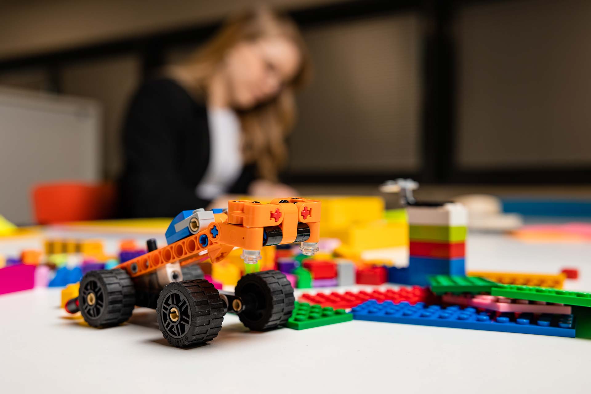 Legoauto ja taustalla opiskelija.