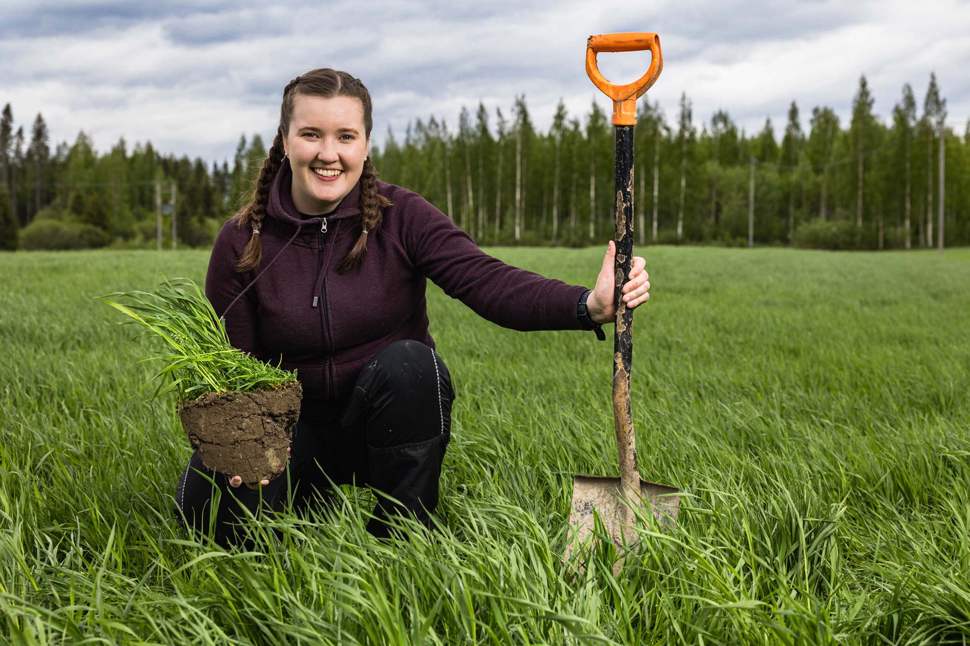 Nainen pellolla lapion kanssa