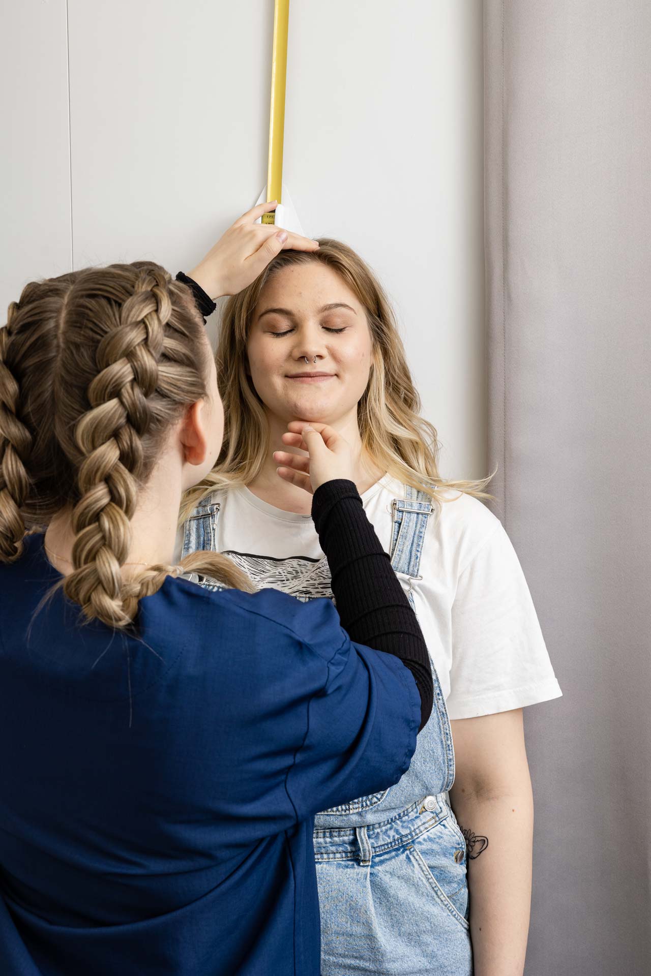 Terveydenhoitajaopiskelijat mittaavat pituutta.