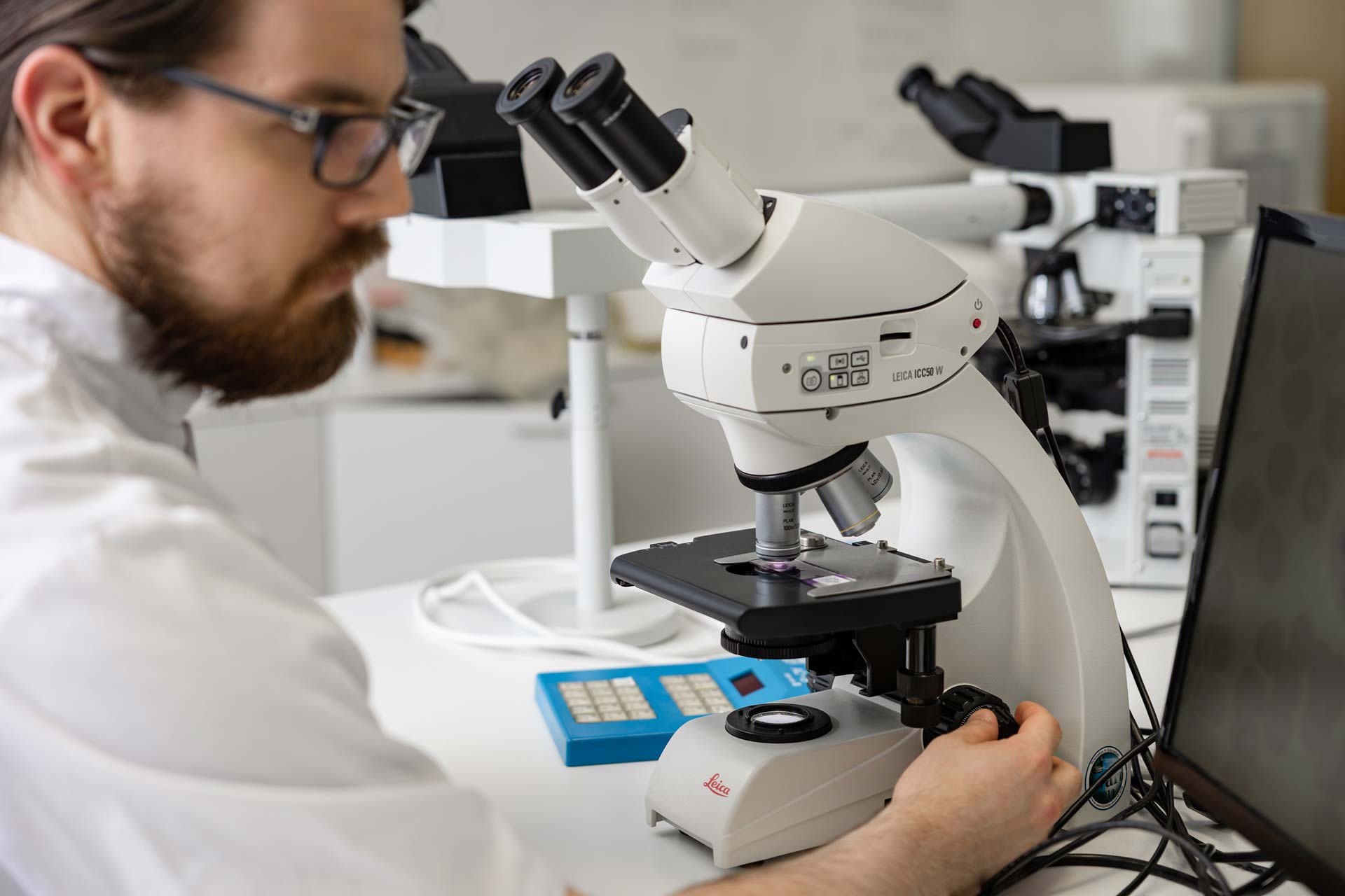 Bioanalyytikko käyttää mikroskooppia.