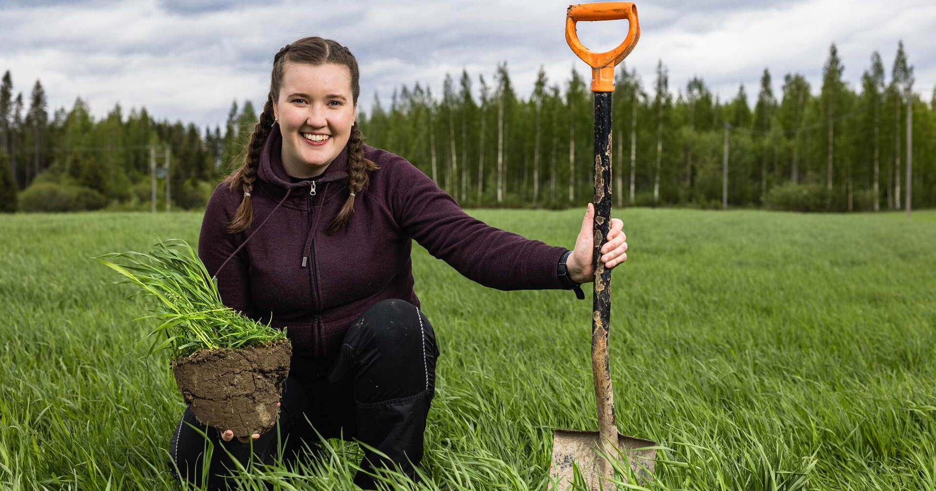 Nainen pellolla lapion kanssa