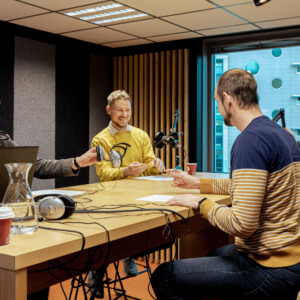 Podcast-studion pöydän ympärillä istuu neljä miesoletettua.