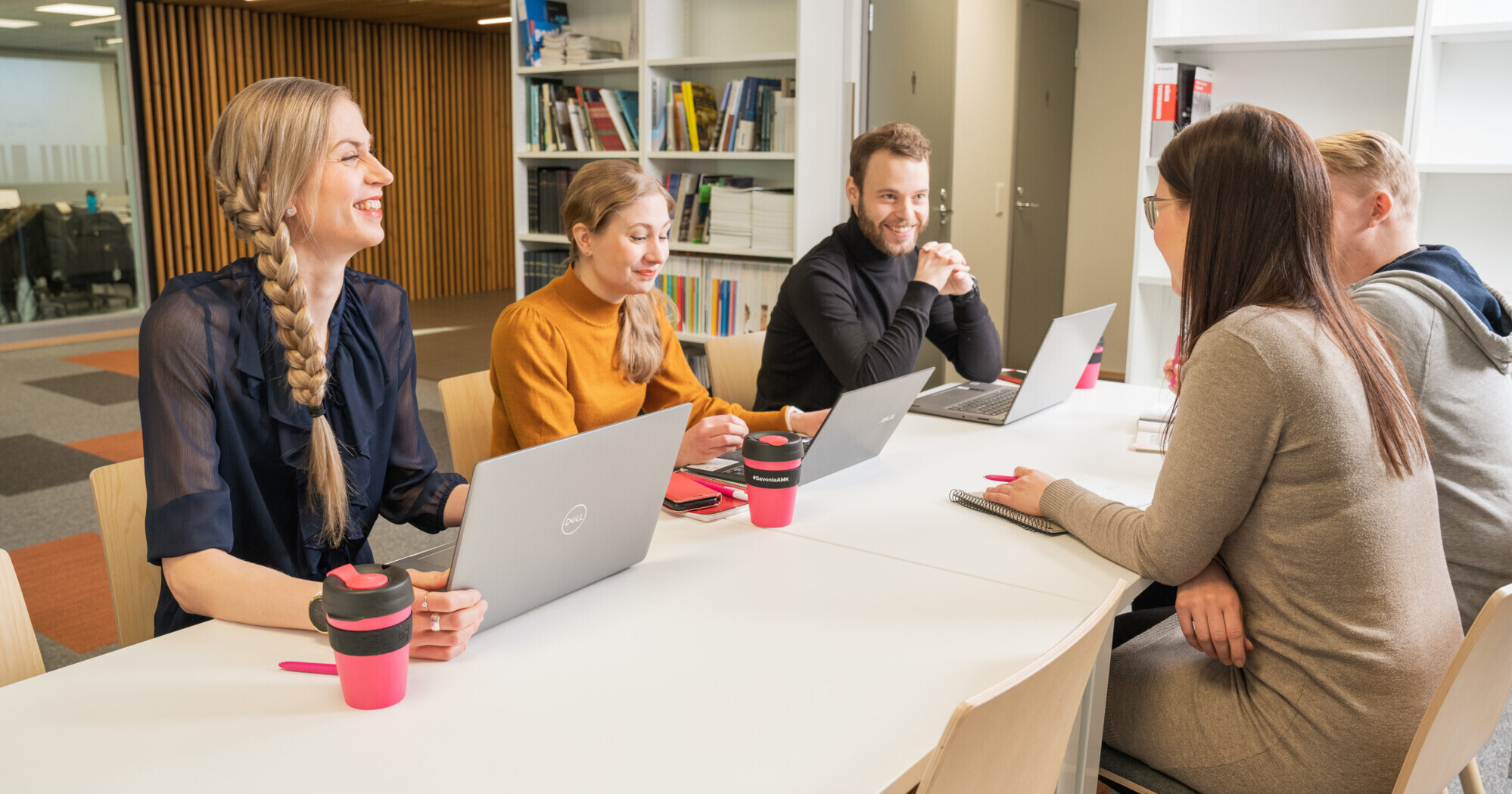 People with laptops sitting around a table.