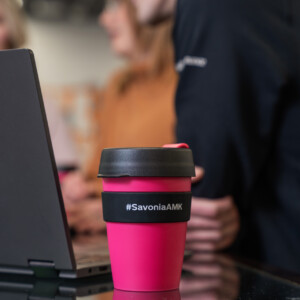 Savonia-brändätty kahvimuki kannettavan tietokoneen vierellä.