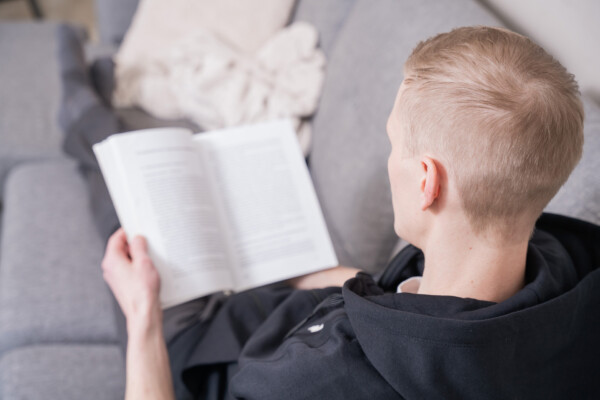 Opiskelija opiskelee rennosti omalla sohvalla oleillen.