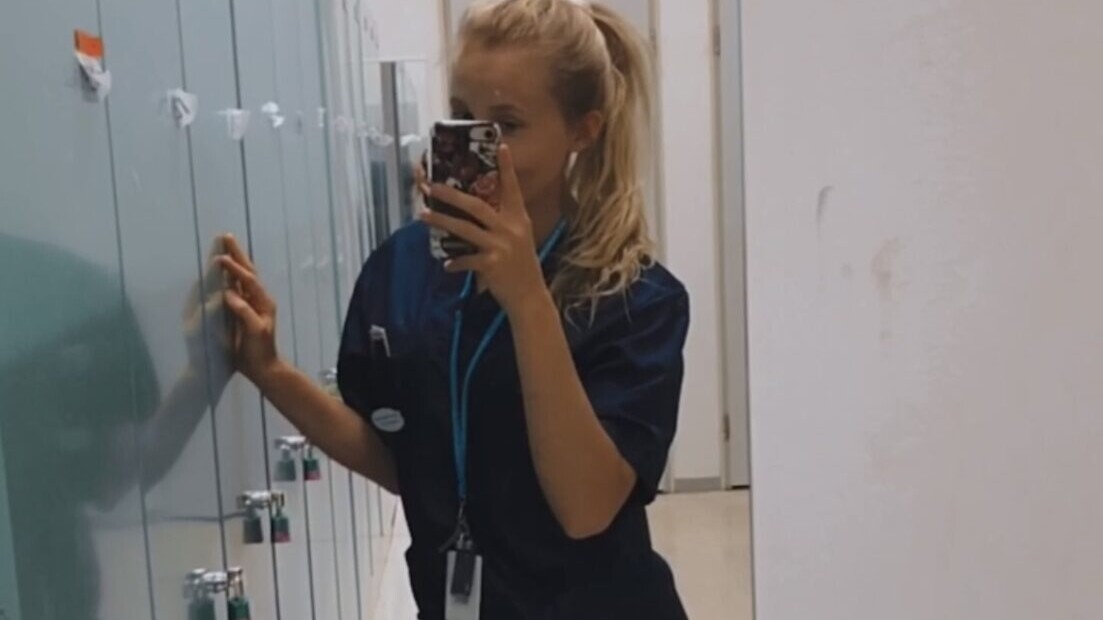tyttö sairaanhoitajan vaatteissa ottaa selfietä peilin kautta