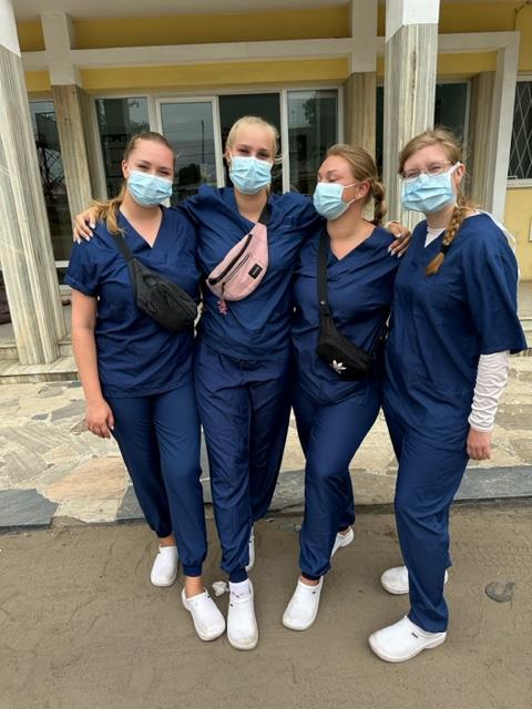 Neljä sairaanhoitajan asuun pukeutunutta naista vierekkäin