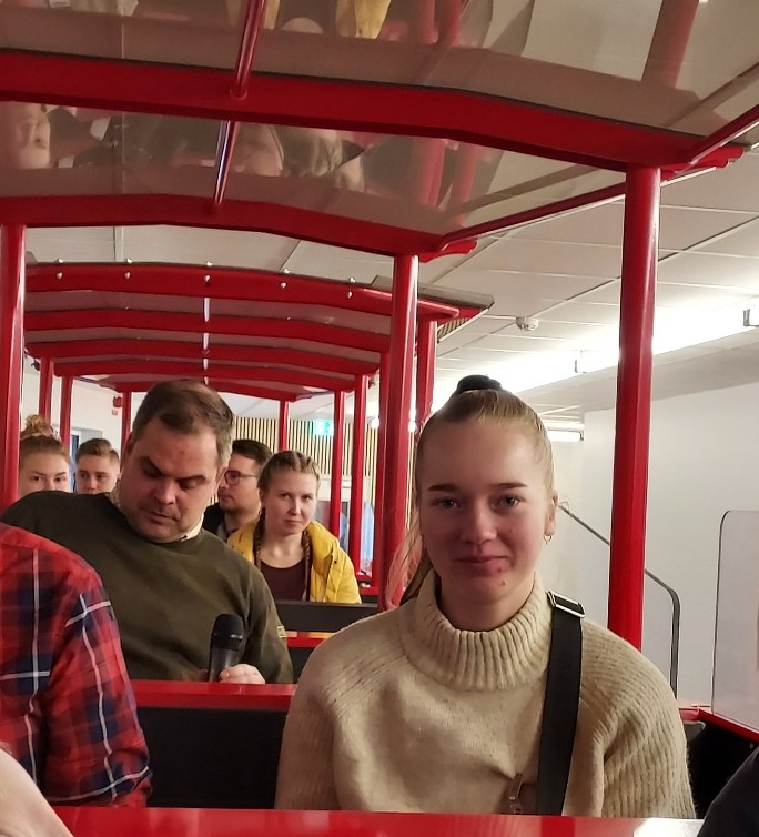 Ihmisiä junanvaunussa istumassa. 