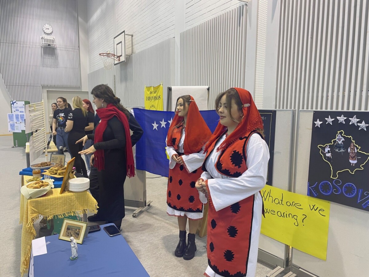 Punamustiin kansallispukuihin pukeutuneita ihmisiä.