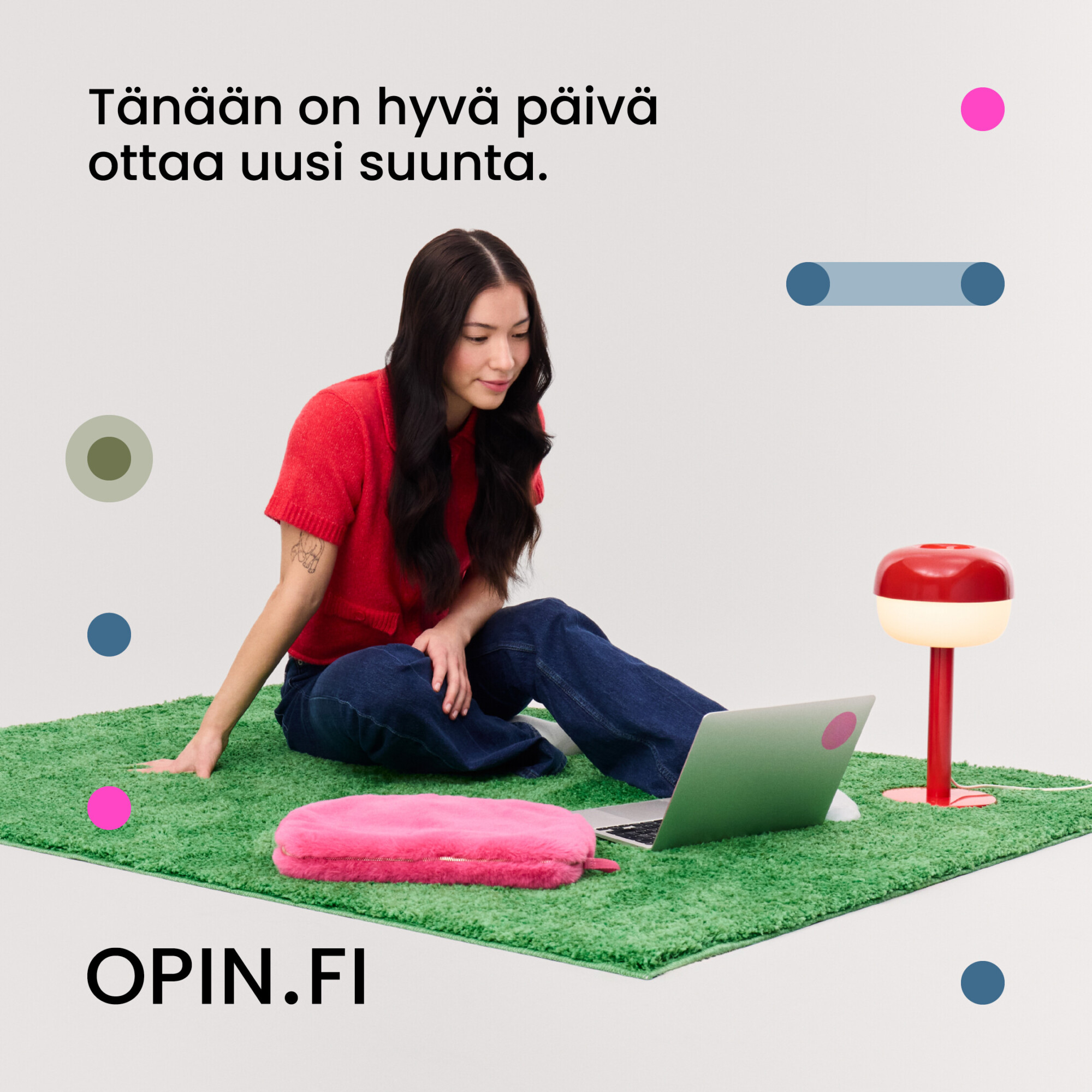 Tyttö istuu maassa ja katselee tietokonetta.