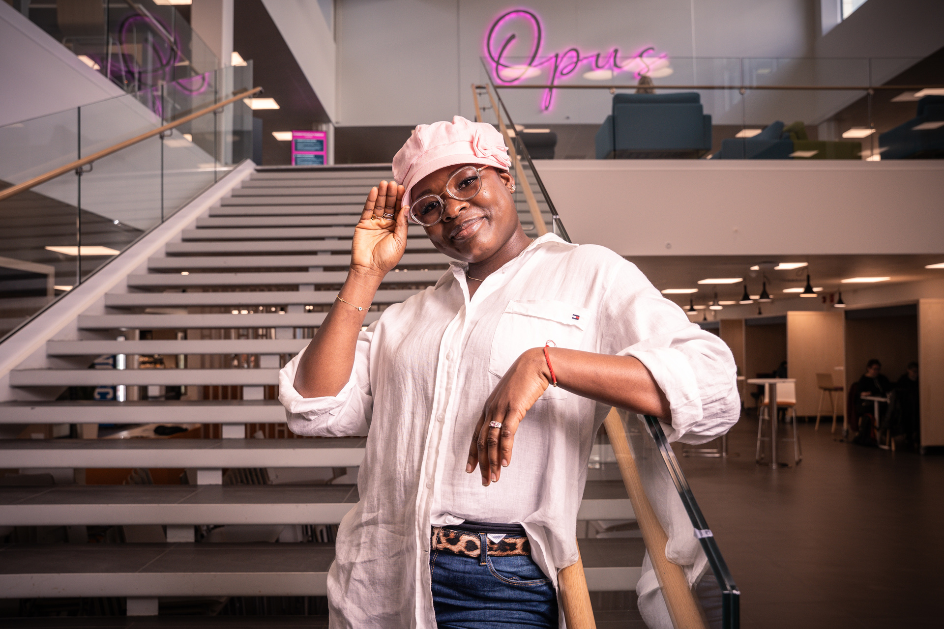 Naisopiskelija nojaa portaiden kaiteeseen.