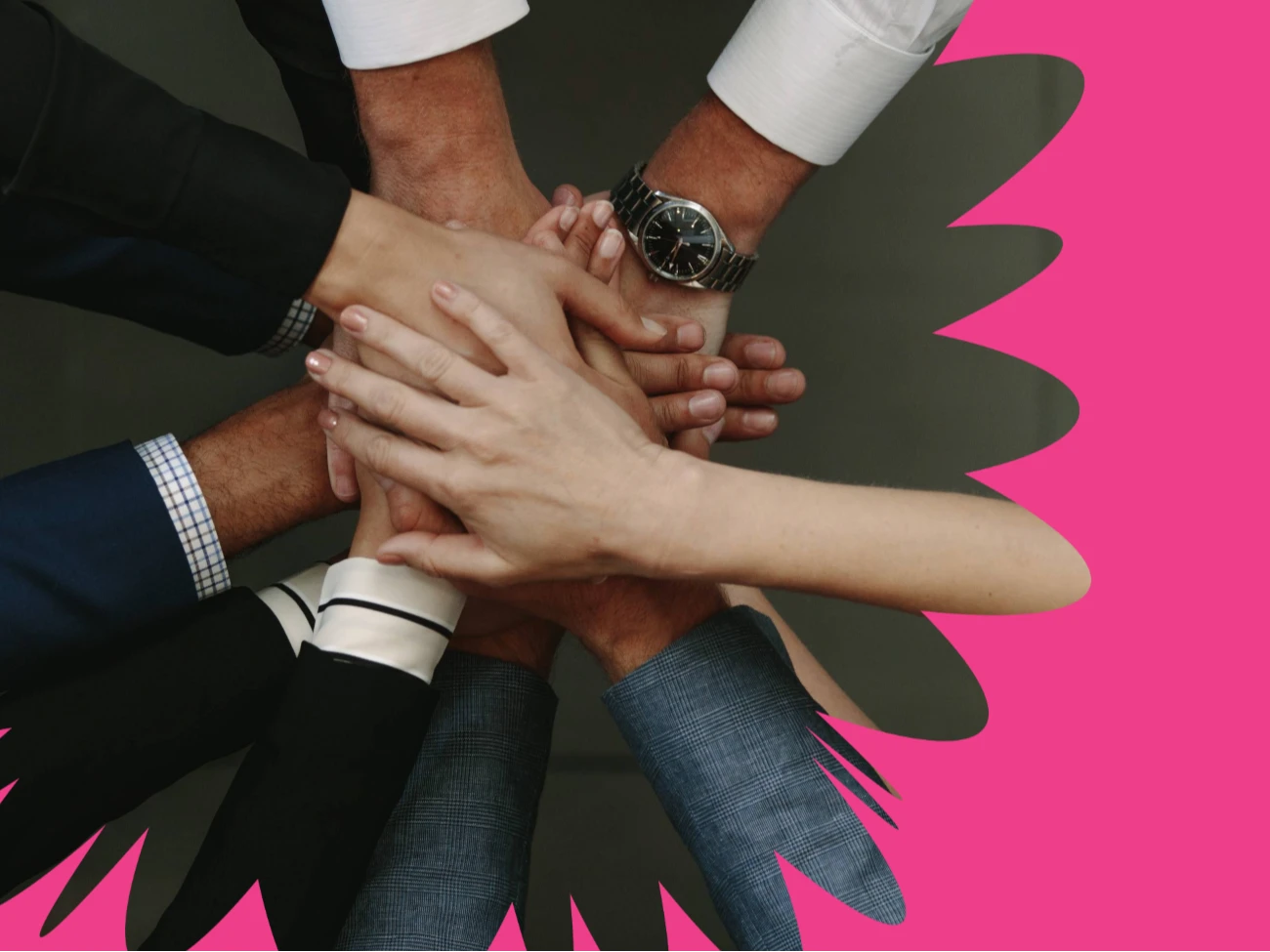 Useita eri ihmisten käsiä on pinottu yhteen tiimityön eleenä, ja taustalla on kirkkaan vaaleanpunainen abstrakti muoto.