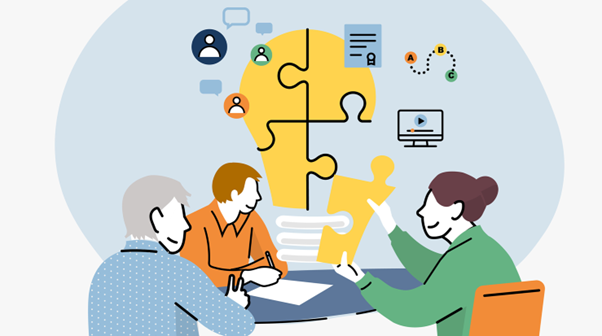 Kolme ihmistä istuu pöydän ääressä tekemässä yhteistyötä, ja taustalla on suuri hehkulampun muotoinen palapeli sekä ihmisiä, asiakirjoja ja tietokonetta kuvaavia kuvakkeita, jotka symboloivat tiimityötä ja ideoiden jakamista.