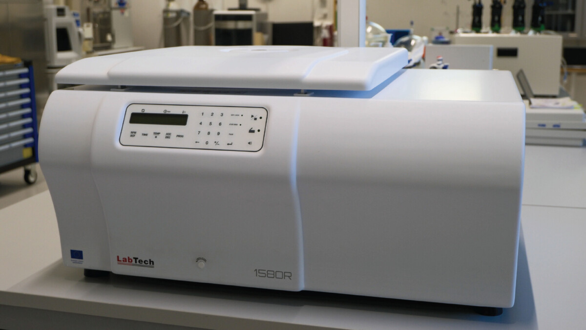 Valkoinen LabTech 1580R -laboratoriosentrifugi istuu laboratorion työtasolla, ja sen etupuolella on digitaalinen ohjauspaneeli, jossa on painikkeet ja näyttö. Taustalla näkyy laboratoriolaitteita.