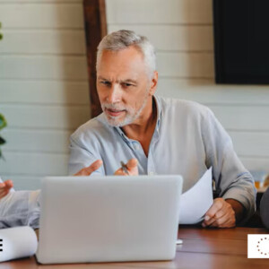 Kolme aikuista istuu pöydän ääressä keskustelemassa papereista kannettavan tietokoneen ääressä. He vaikuttavat sitoutuneilta ja yhteistyökykyisiltä. CHANCE-logo ja Euroopan unionin yhteisrahoituksen logo näkyvät alakulmissa.