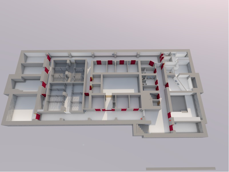 Rakennuksen 3D-pohjapiirustus, jossa on useita huoneita, käytäviä ja portaita. Suunnitelmassa on harmaat seinät ja punaisia korostuksia välein sisäseinillä. Pohjapiirros on suorakulmainen ja siinä on erikokoisia osastoja.