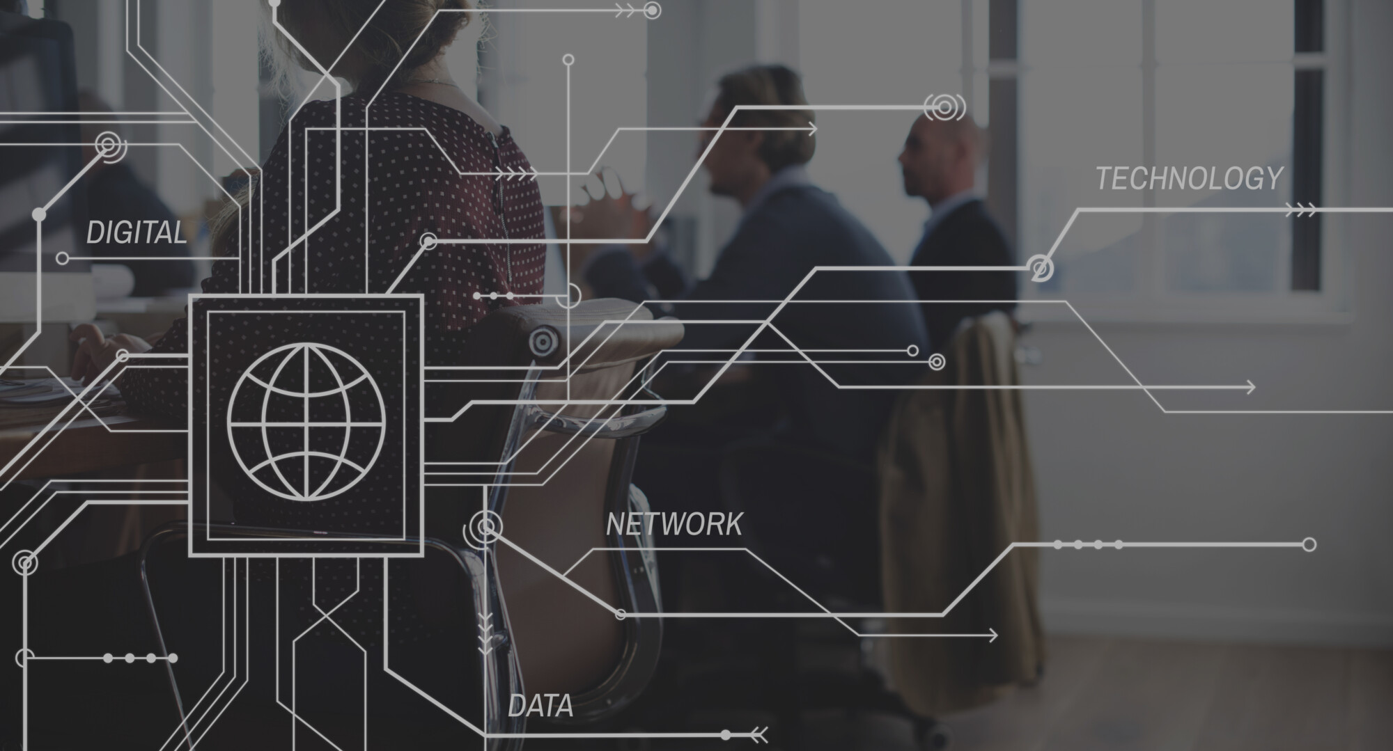 Toimistossa työskentelevät ihmiset, joiden kuvassa on abstrakteja digitaalisia verkkografiikoita, kuten kuvakkeita ja sanoja, kuten DIGITAL, TECHNOLOGY, NETWORK ja DATA, jotka ovat kuvan päällä ja edustavat liitettävyyttä ja teknologiaa.