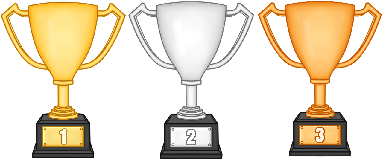 Kuvassa on kolme pokaalia: kultainen pokaali 1, hopeinen pokaali 2 ja pronssinen pokaali 3, joista jokainen on mustalla alustalla ja edustaa ensimmäistä, toista ja kolmatta sijaa.