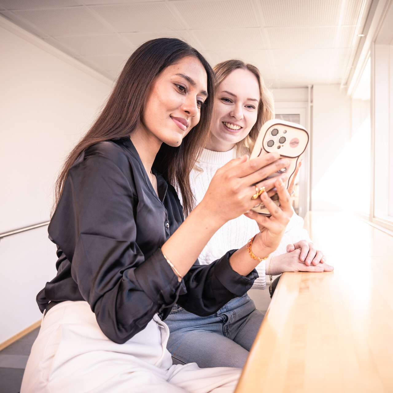 Kaksi opiskelijaa ottaa selfietä.