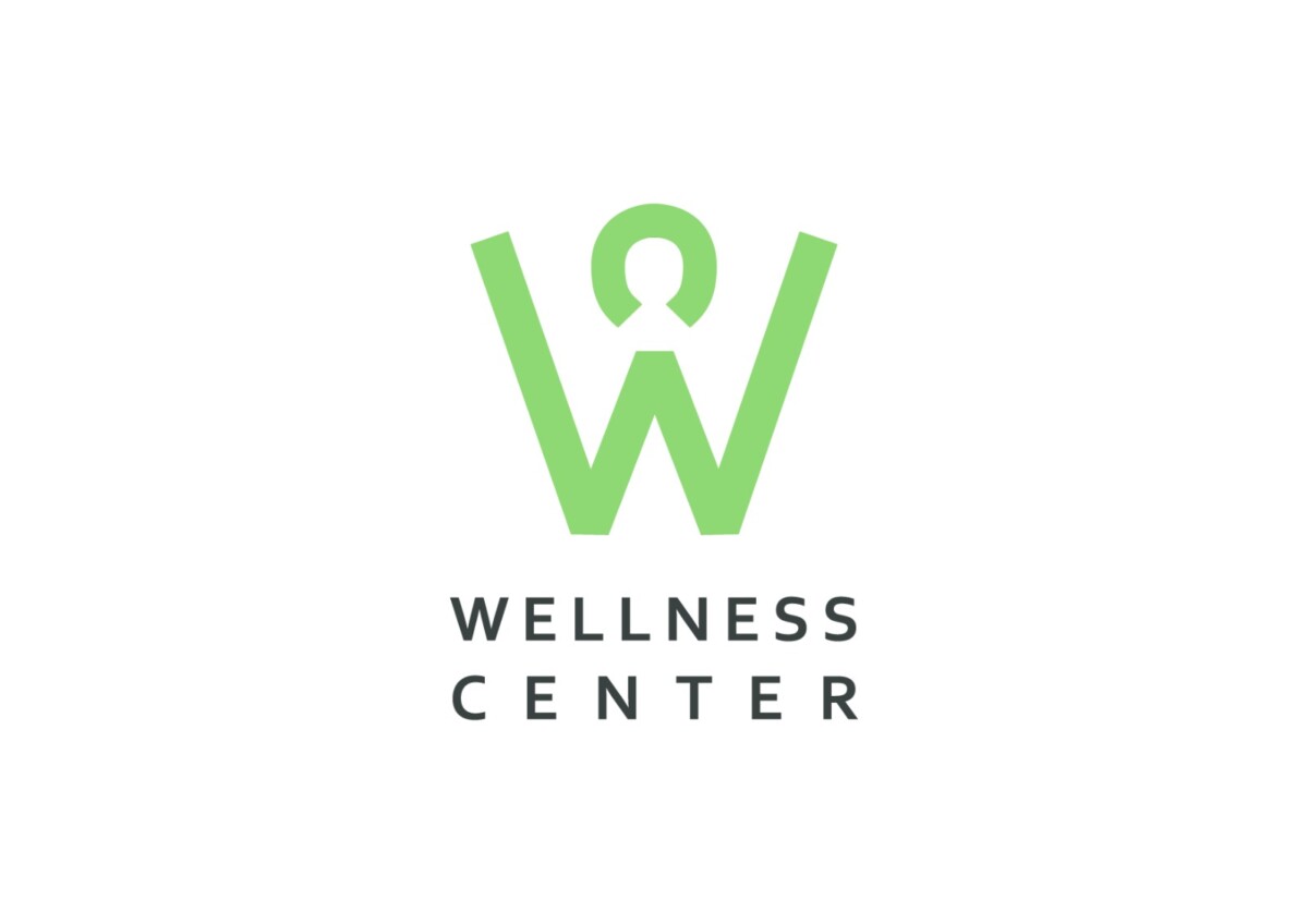 Vihreä W-logo, jonka keskellä on avaimenreikän muotoinen aukko, ja sen yläpuolella teksti ”WELLNESS CENTER” mustilla isolla kirjaimilla valkoisella taustalla.