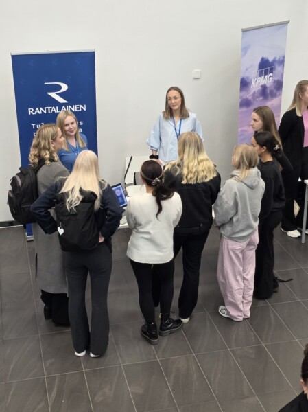 Pöydän takana seisova nainen puhuu opiskelijaryhmälle Rantalaisen uramessujen osastolla.