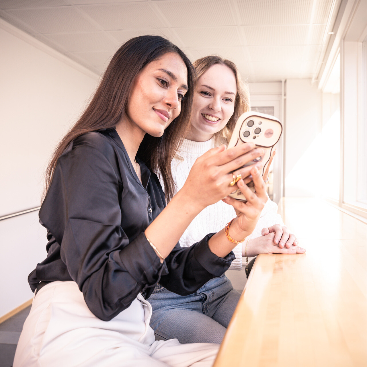Kaksi opiskelijaa ottaa selfietä.