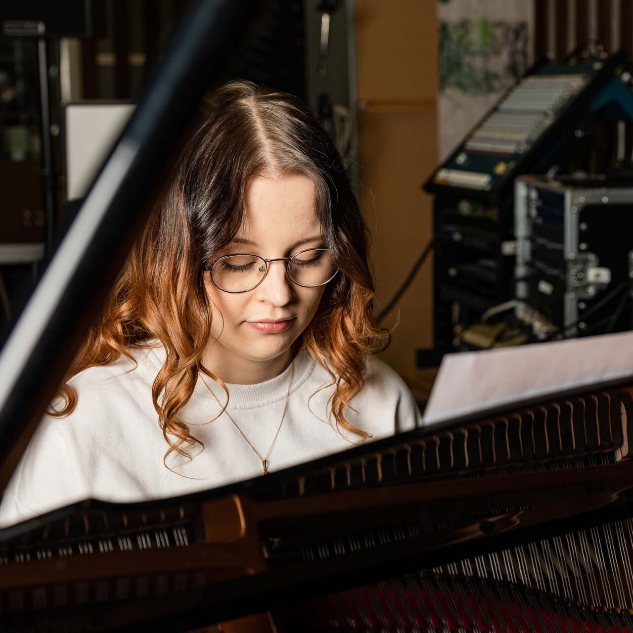 Musiikin opiskelija flyygelin äärellä.
